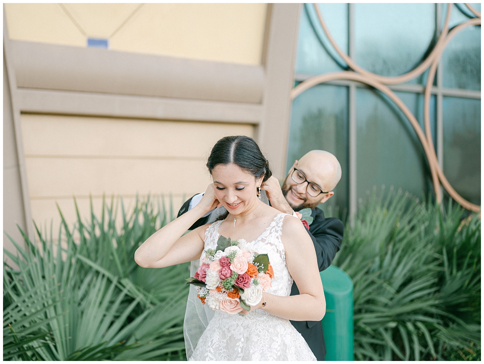  Groom helps bride put on wedding day necklace. By Elizabeth Kane Photography at Disney's Riviera Resort in Orlando Florida