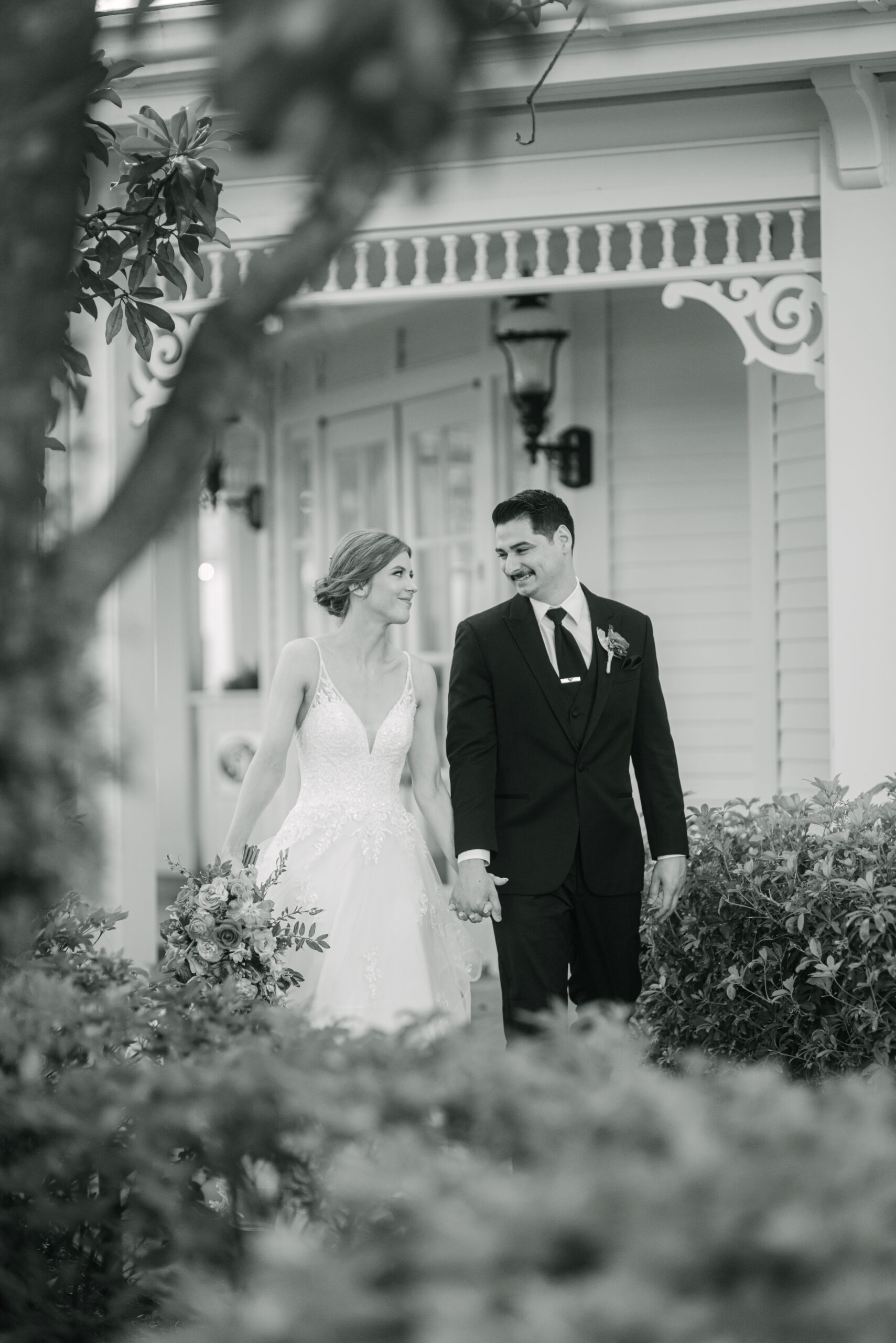 Candid shot of bride and groom walking hand in hand through a garden by Elizabeth Kane Photography Orlando Florida Destination Disney Wedding Photographer at Grand Floridian Resort and Spa