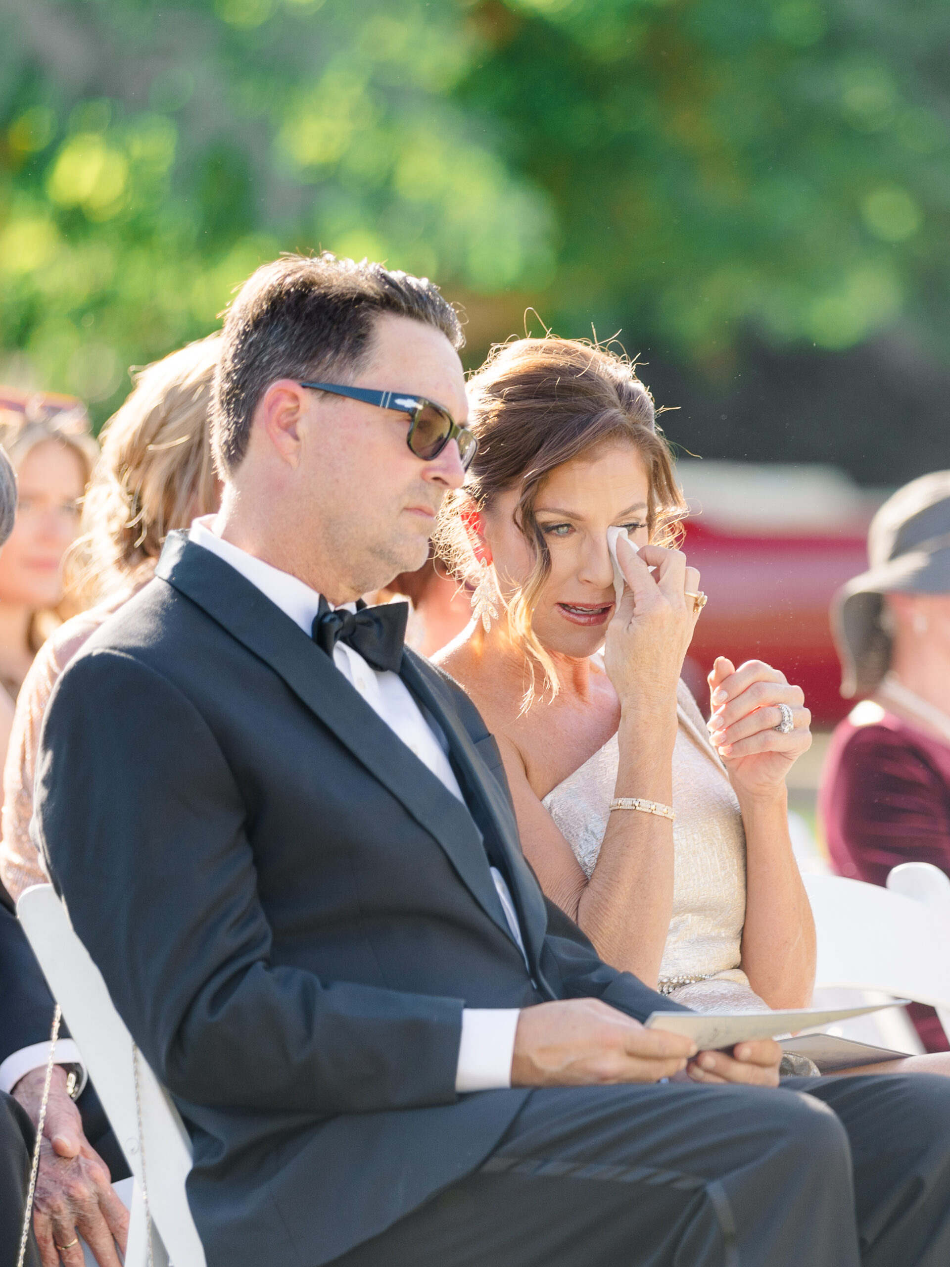 Mother of the bride wiping away tears during the ceremony at a Bougainvillea Estate wedding in Indio, CA, captured in a candid emotional moment.