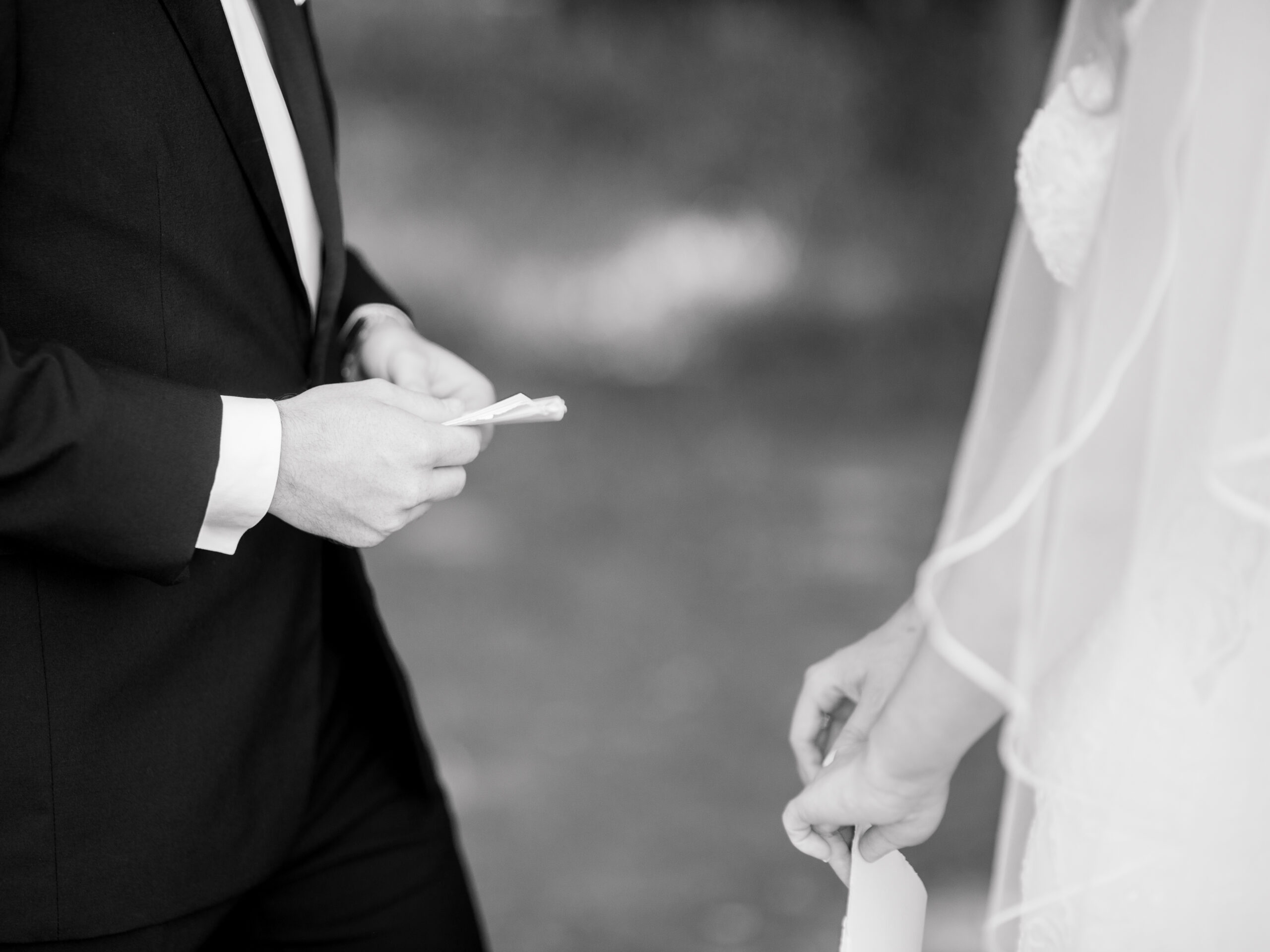 Black and white photo of a bride and groom privately exchanging handwritten vows, captured in an emotional moment by a documentary wedding photographer in Philadelphia.