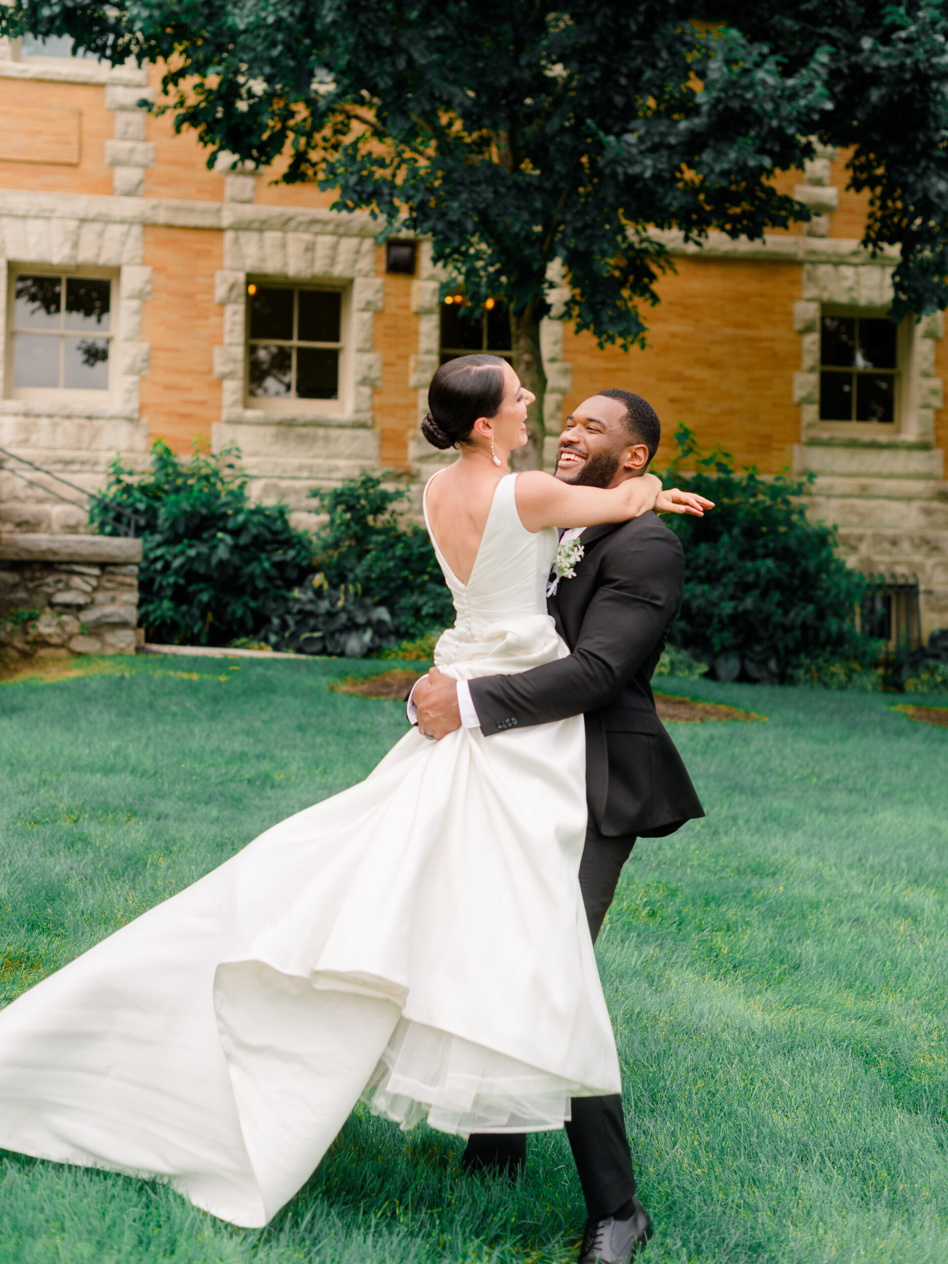 Bride and groom share a joyful embrace during a historic estate wedding at Cairnwood Estate in Philadelphia, captured by Elizabeth Kane Photography, highlighting timeless romance and luxury wedding photography.