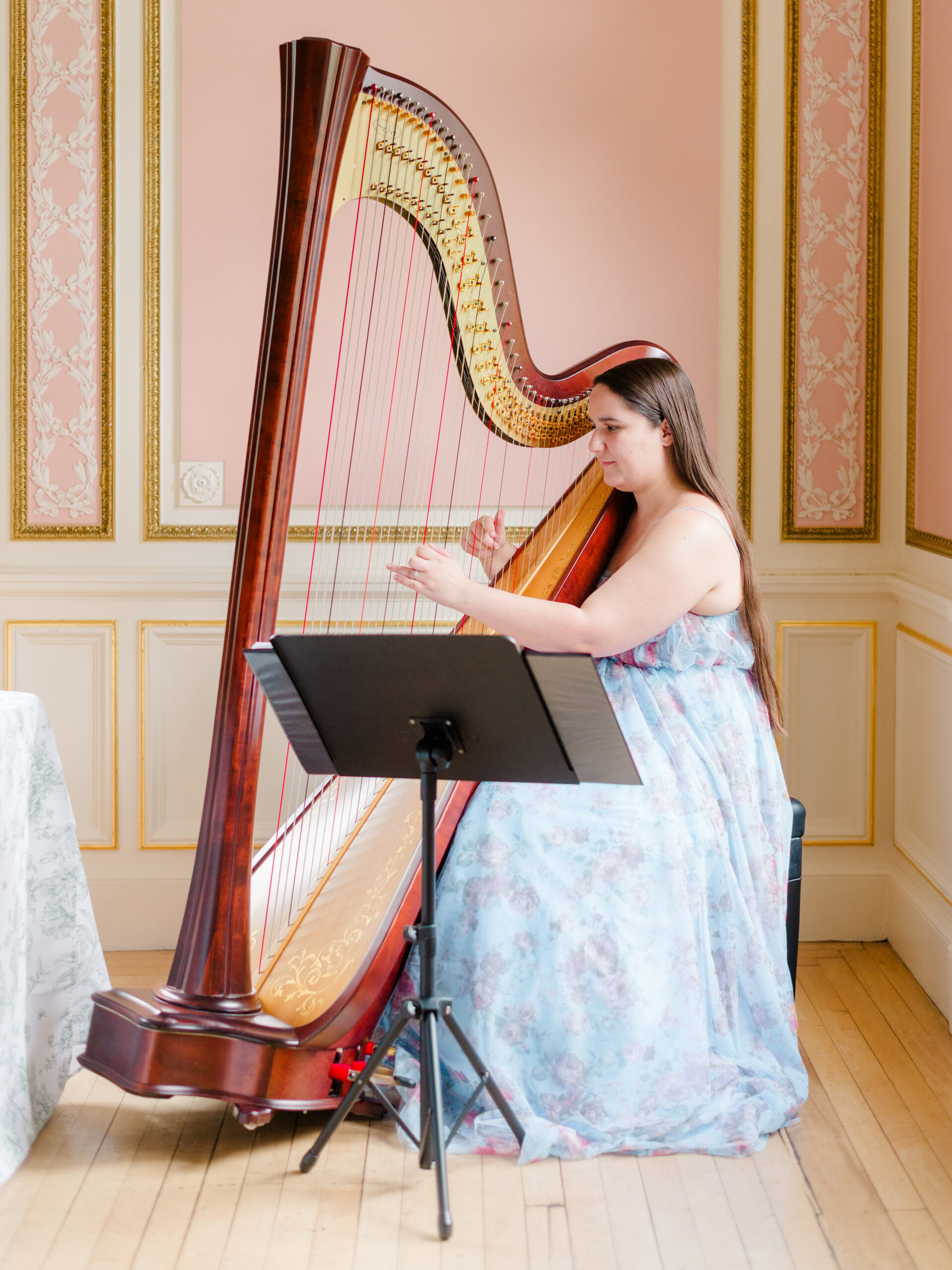 Live harp music during a wedding at Cairnwood Estate wedding venue in Bryn Athyn, Pennsylvania, performed in a historic interior room.