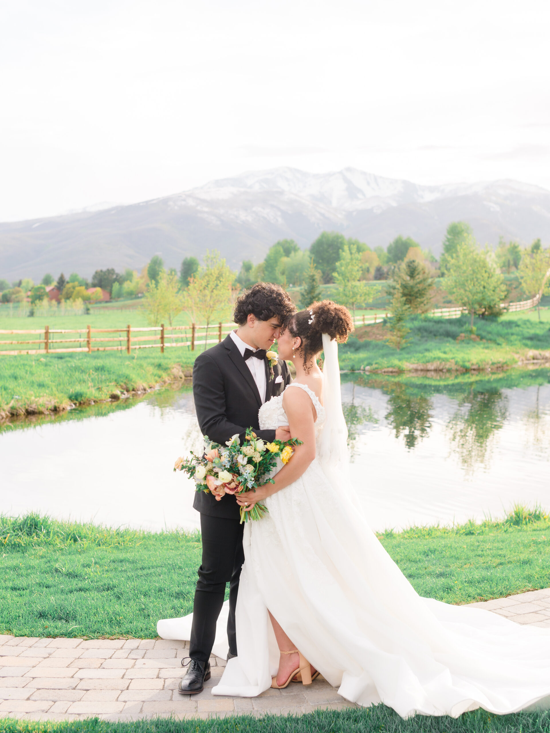 Wedding couple embracing during golden hour portraits by the water, photographed by an experienced wedding photographer