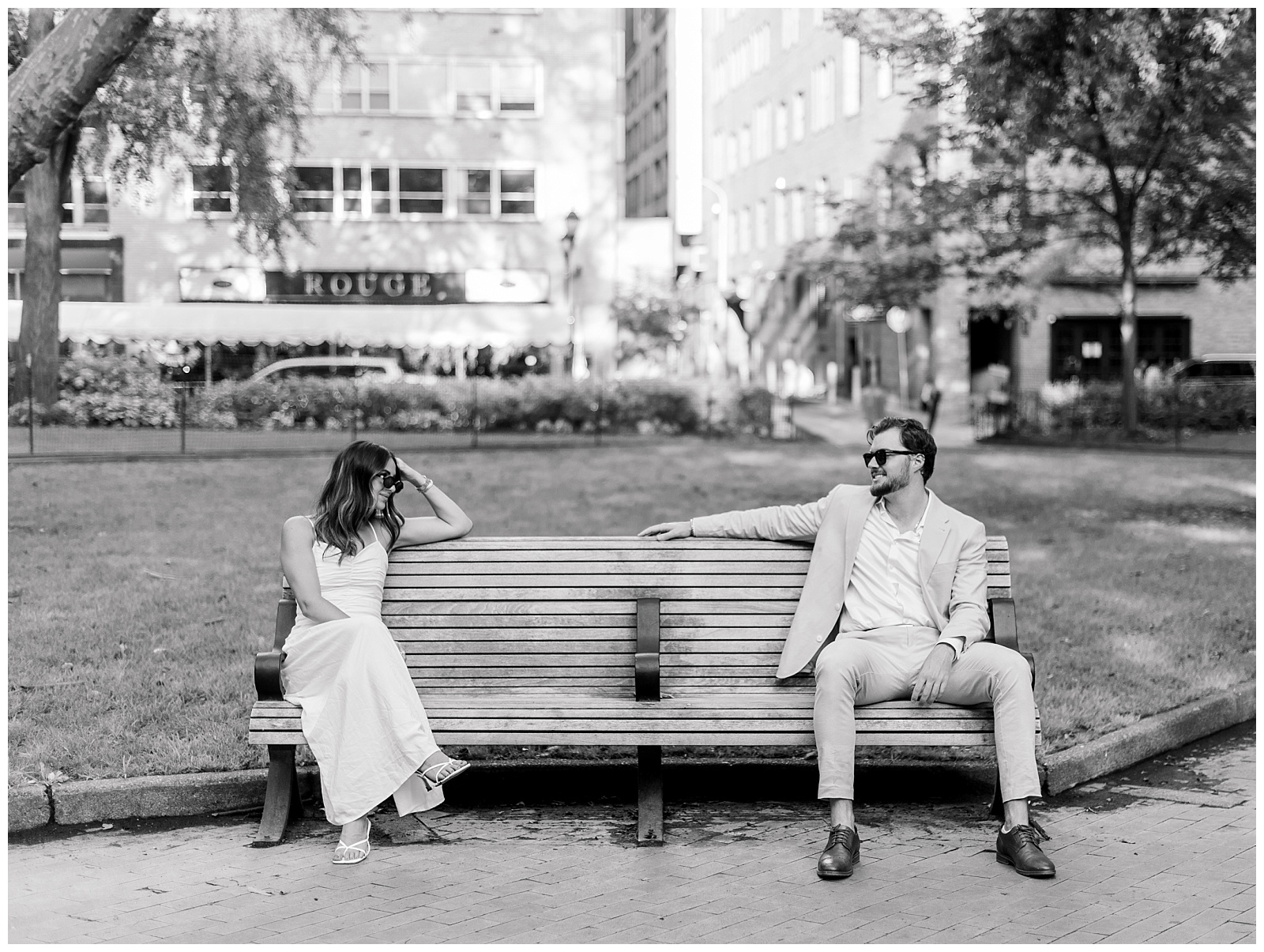 Candid black and white moment from a Philadelphia engagement session as a couple sits together in Rittenhouse Square